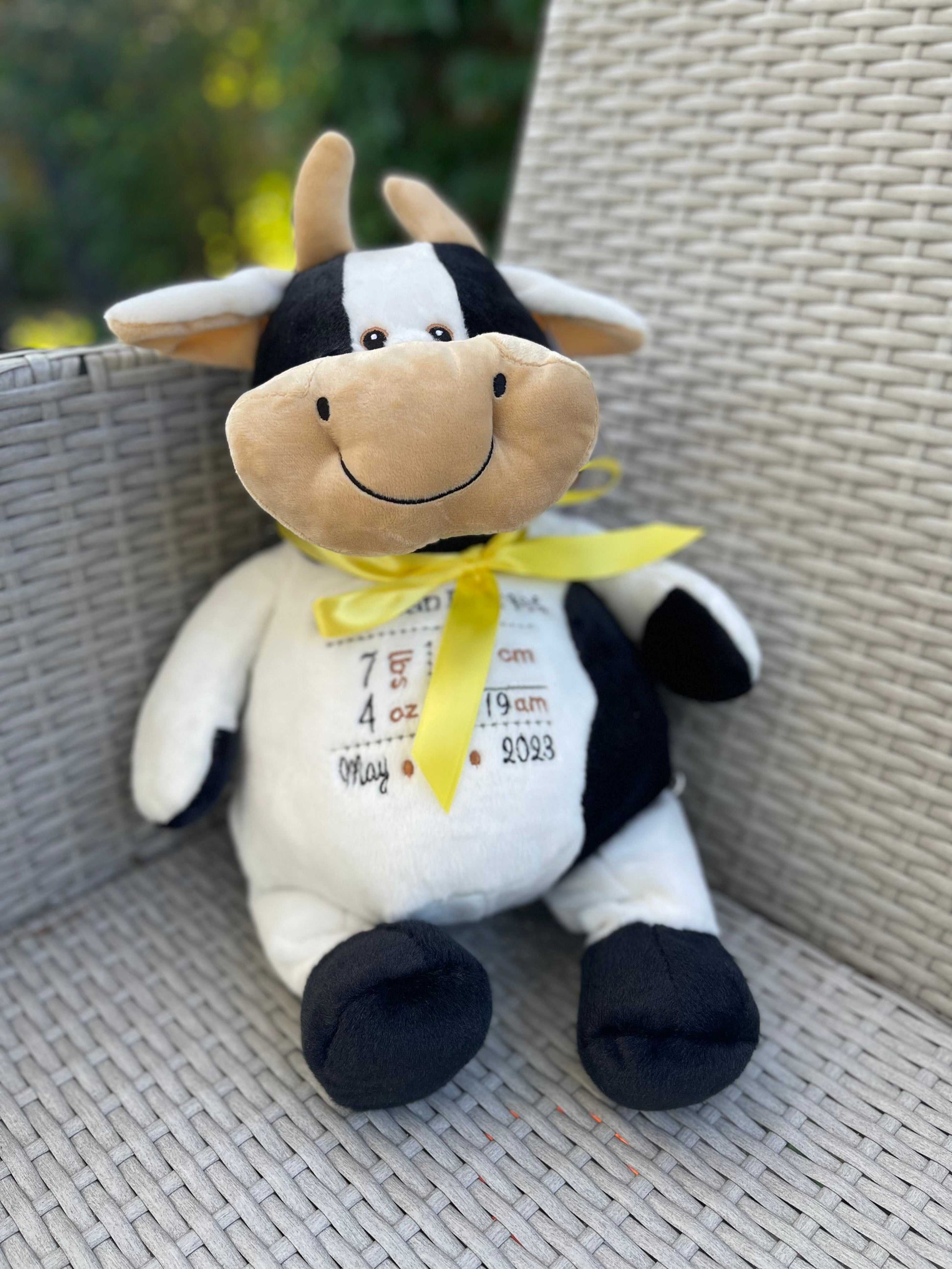 Personalized Birth Stat Embroidered Moose plush toy on chair, perfect for nursery decor.