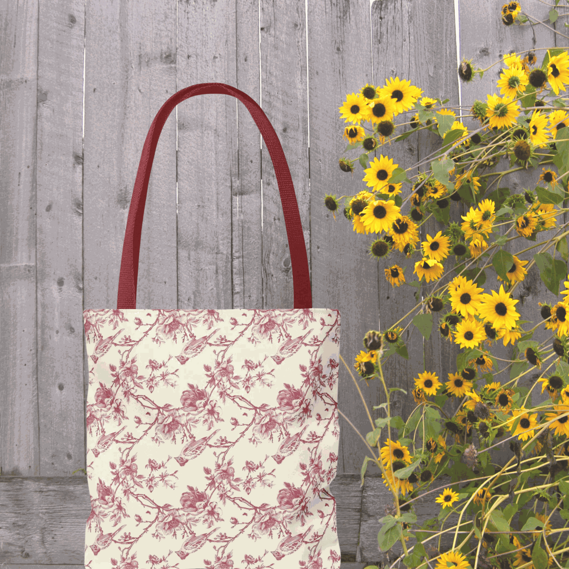 Pink Toile Tote Bag with flower print, reusable canvas, stylish and multi-purpose, next to vibrant yellow flowers.