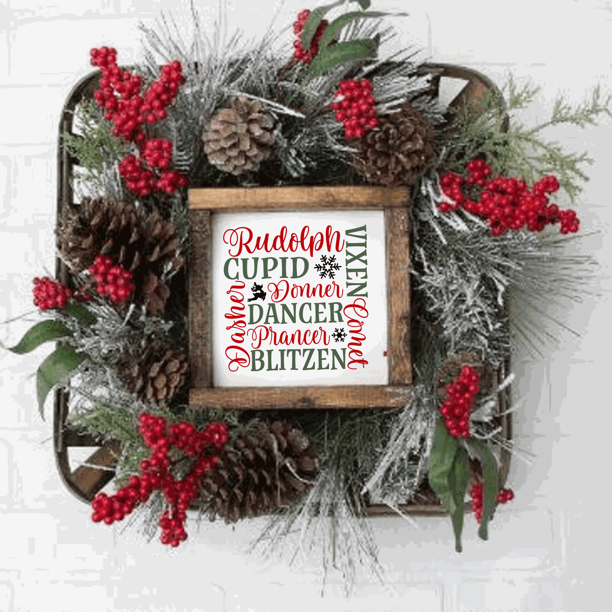 Handmade wood sign featuring Santa's reindeer names in red and green lettering on a white background, framed with stained wood and surrounded by holiday greenery and red berries.