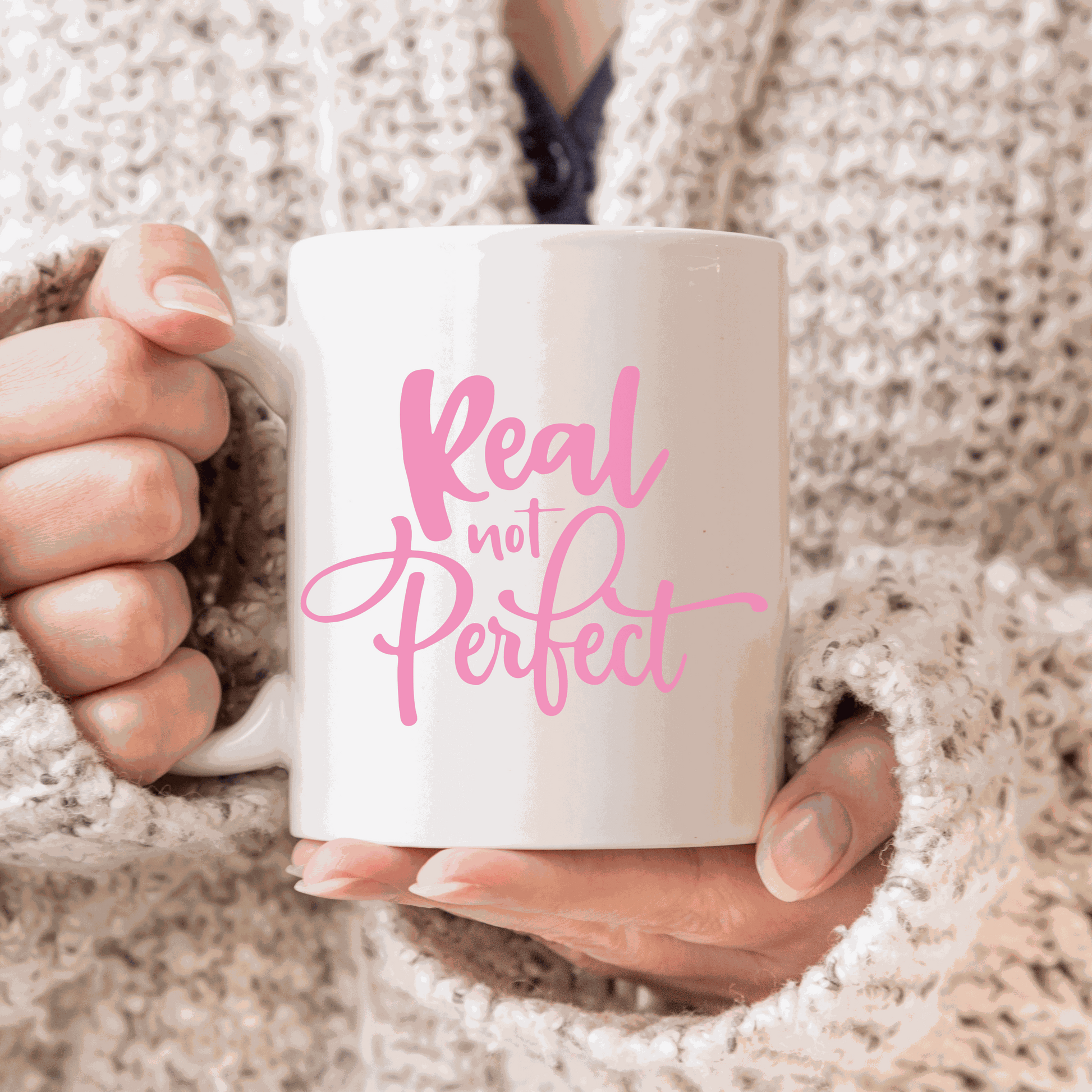 Ceramic coffee mug with "Real Not Perfect" design in pink.