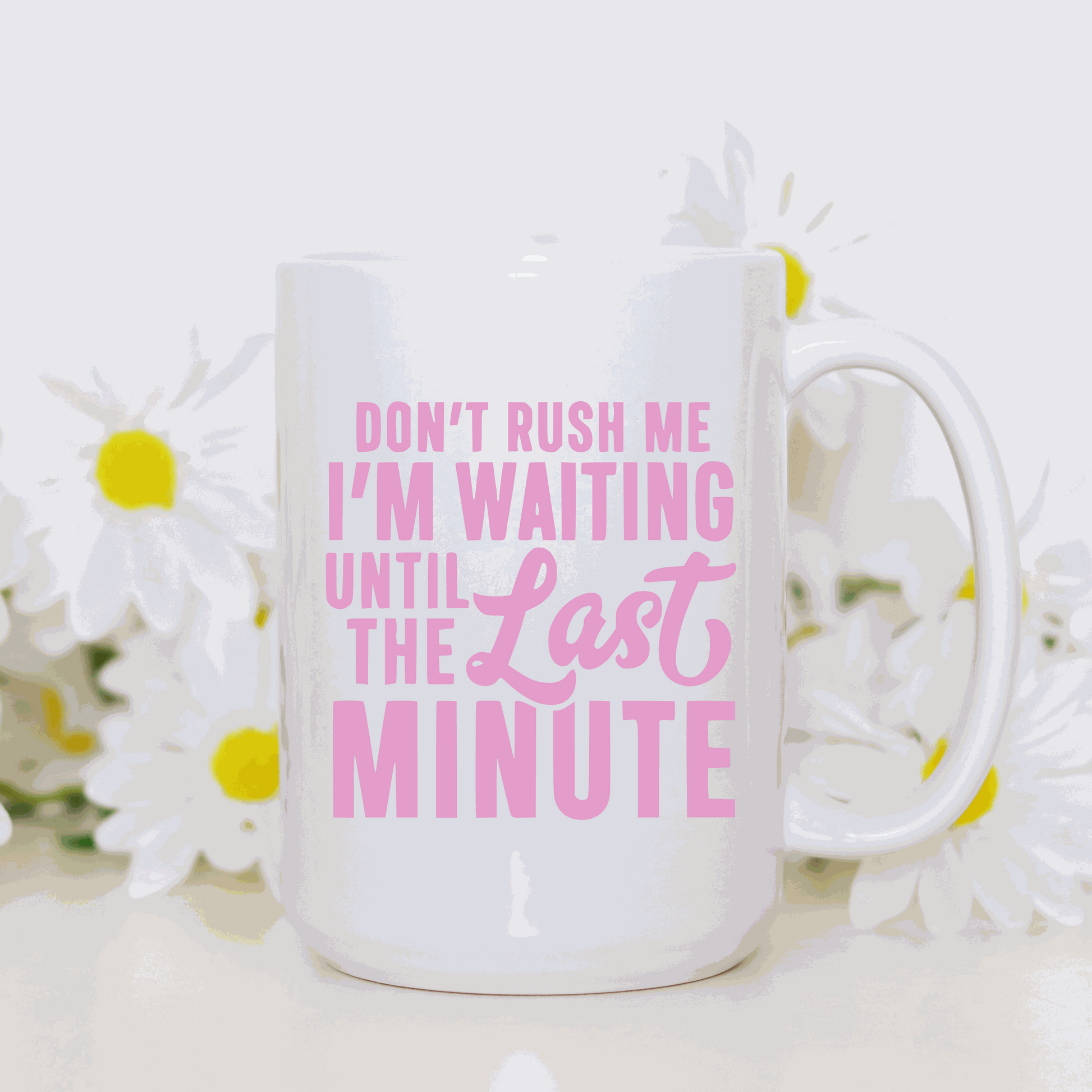 Ceramic coffee mug with "Don't Rush Me I'm Waiting Until the Last Minute" printed in pink text.