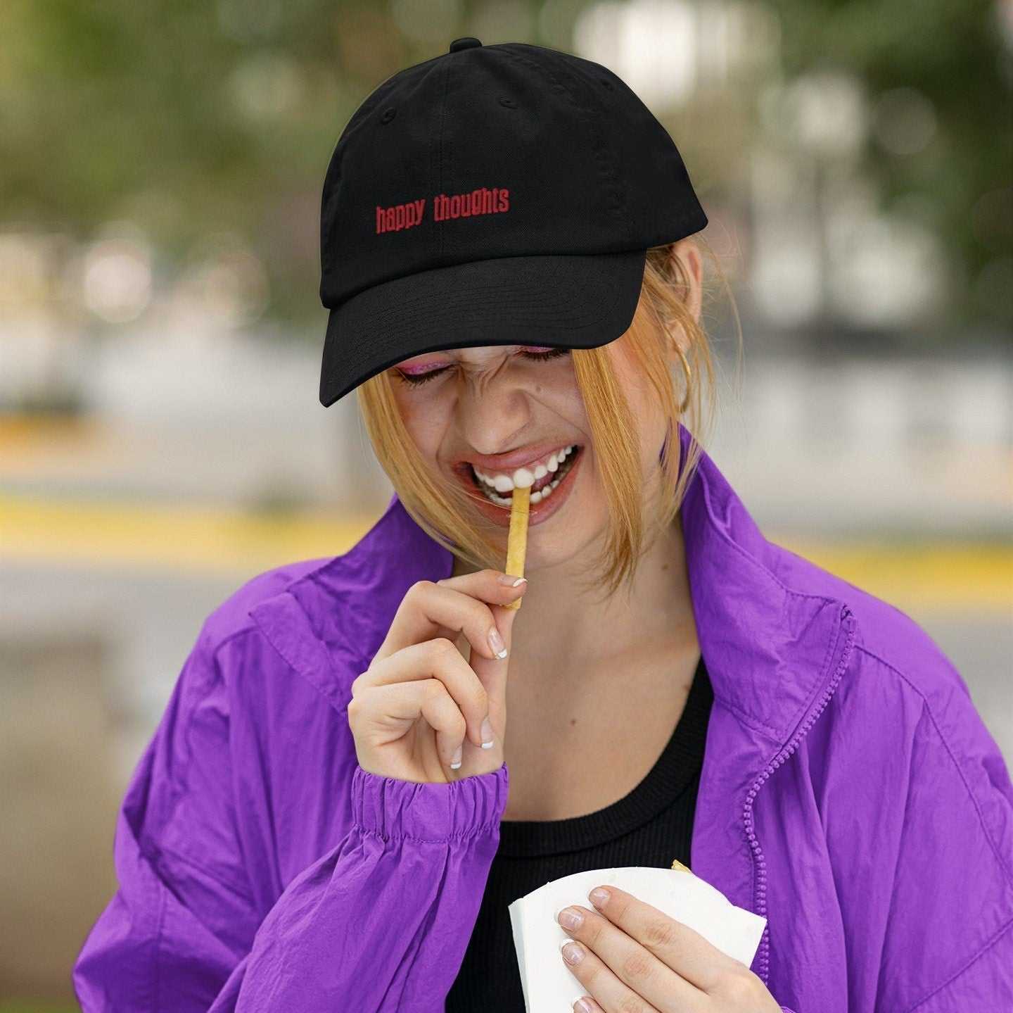 Black personalized cap with red embroidery worn by woman in purple jacket outdoors