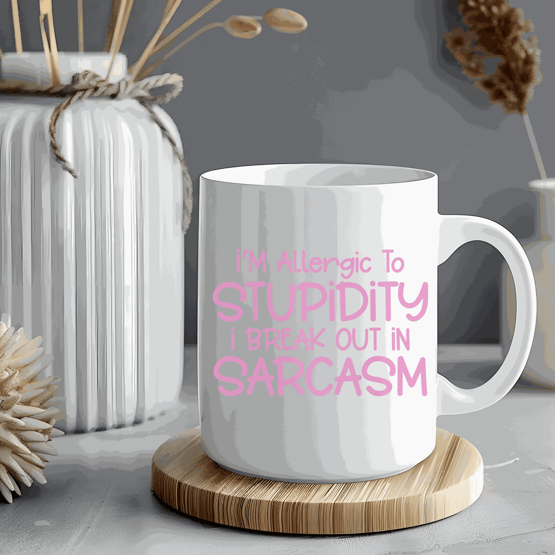 Ceramic coffee mug with "I'm Allergic to Stupidity" text in pink.