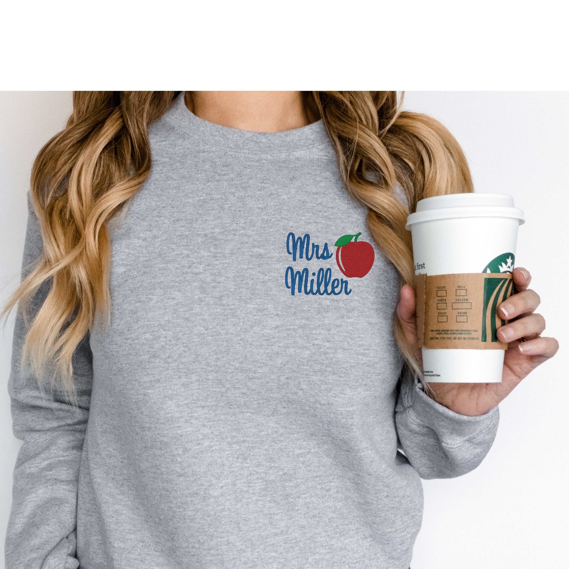 Personalized teacher sweatshirt with name and apple design, perfect gift for teachers.