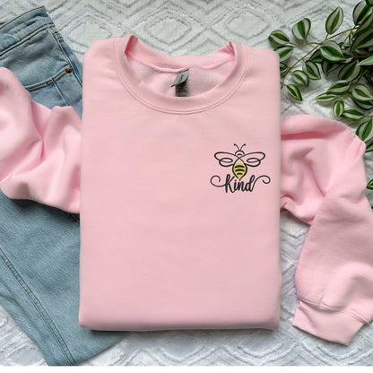 Bumble Bee "Be Kind" embroidered pink sweatshirt on display.
