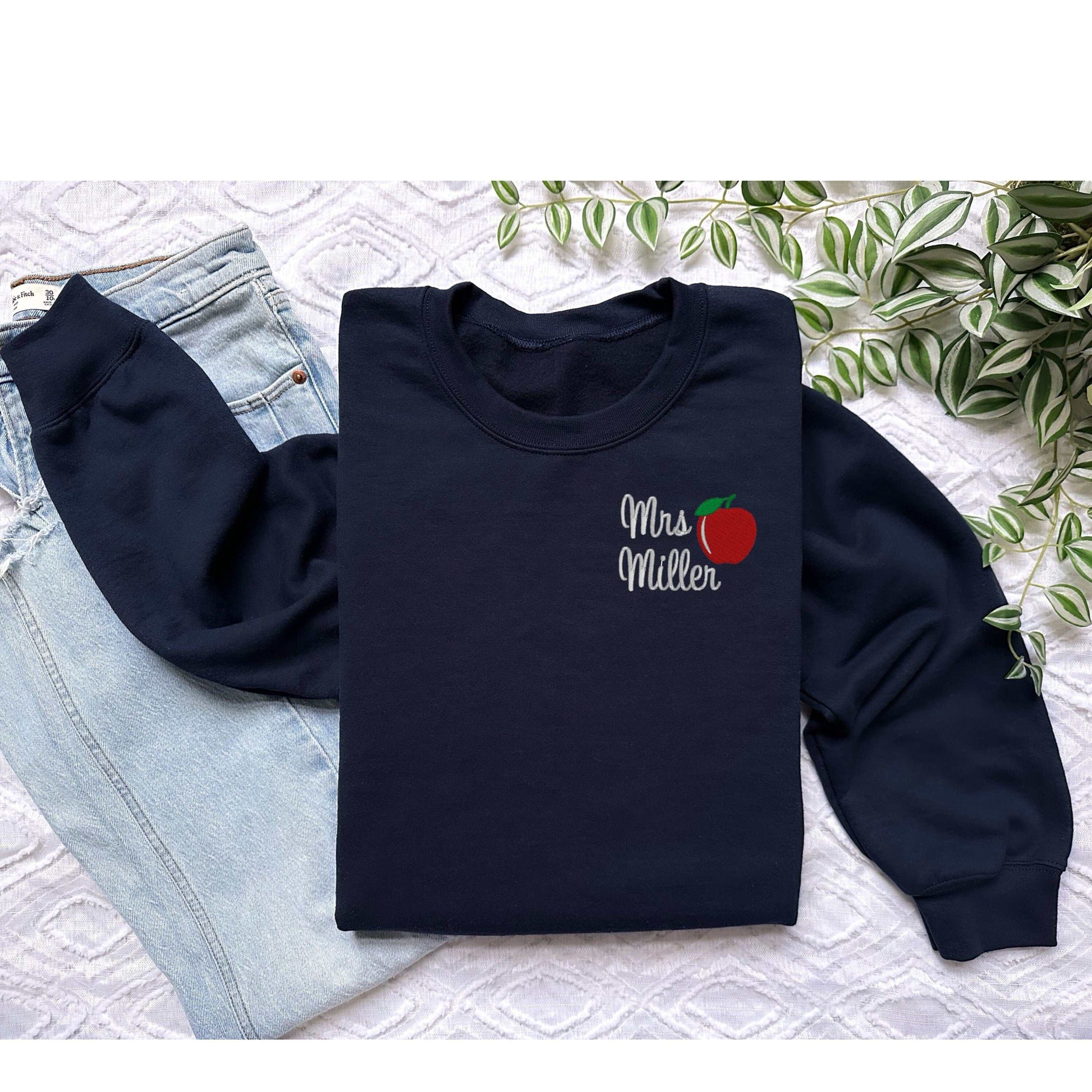 Personalized teacher sweatshirt with apple design and custom name, ideal gift for teachers.