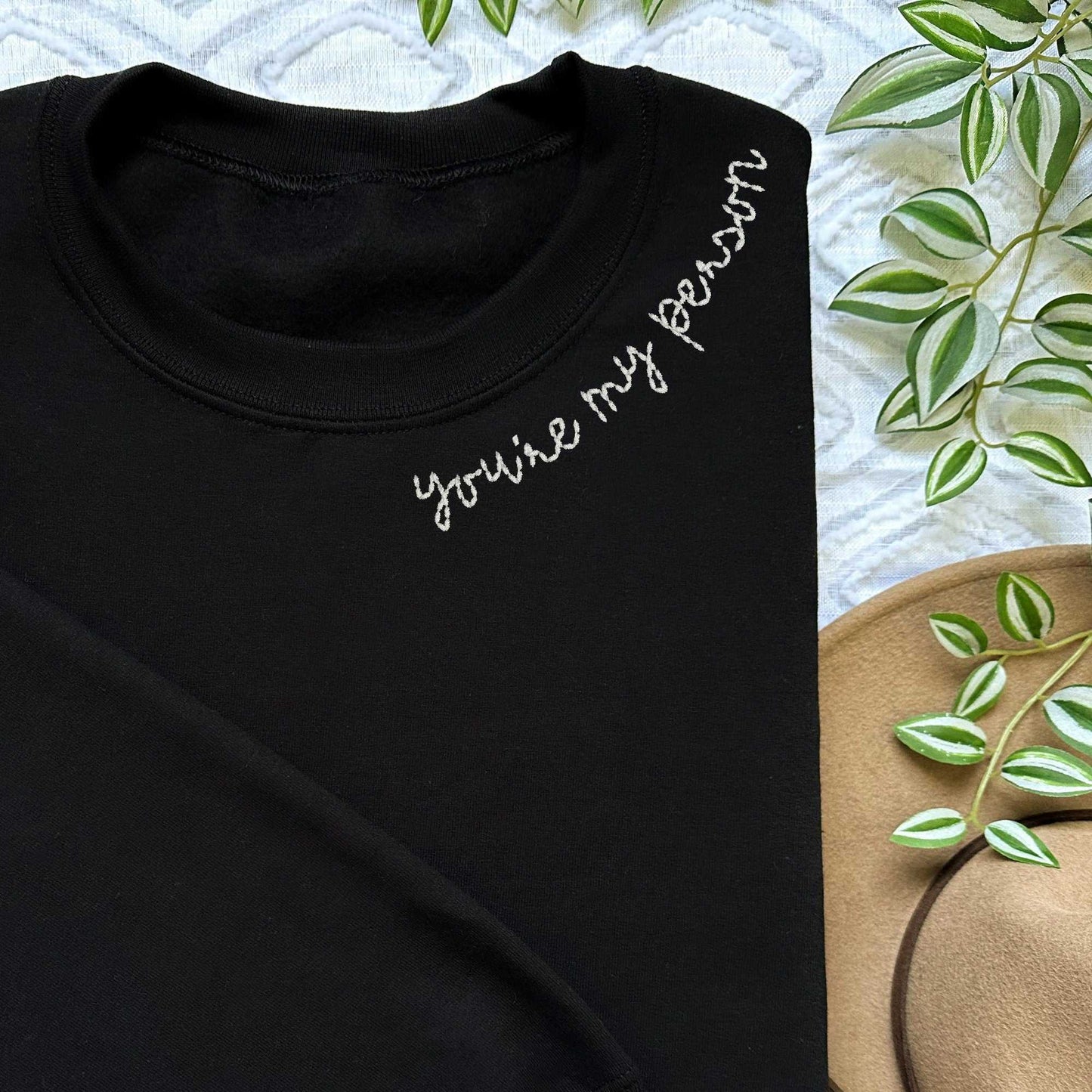 Couple matching sweater with embroidered "You're My Person" collar on black crewneck.