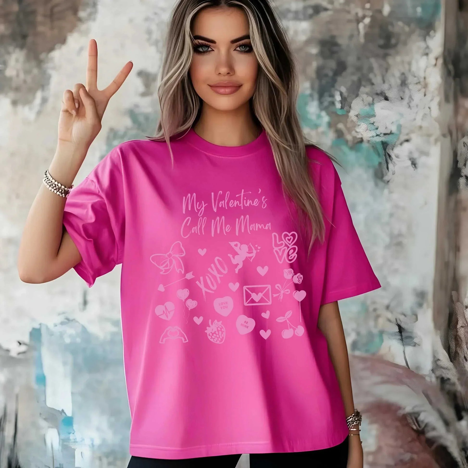 Pink Valentine's Day T-shirt with "My Valentine's Call Me Mama" doodle design, worn by a woman showing a peace sign.