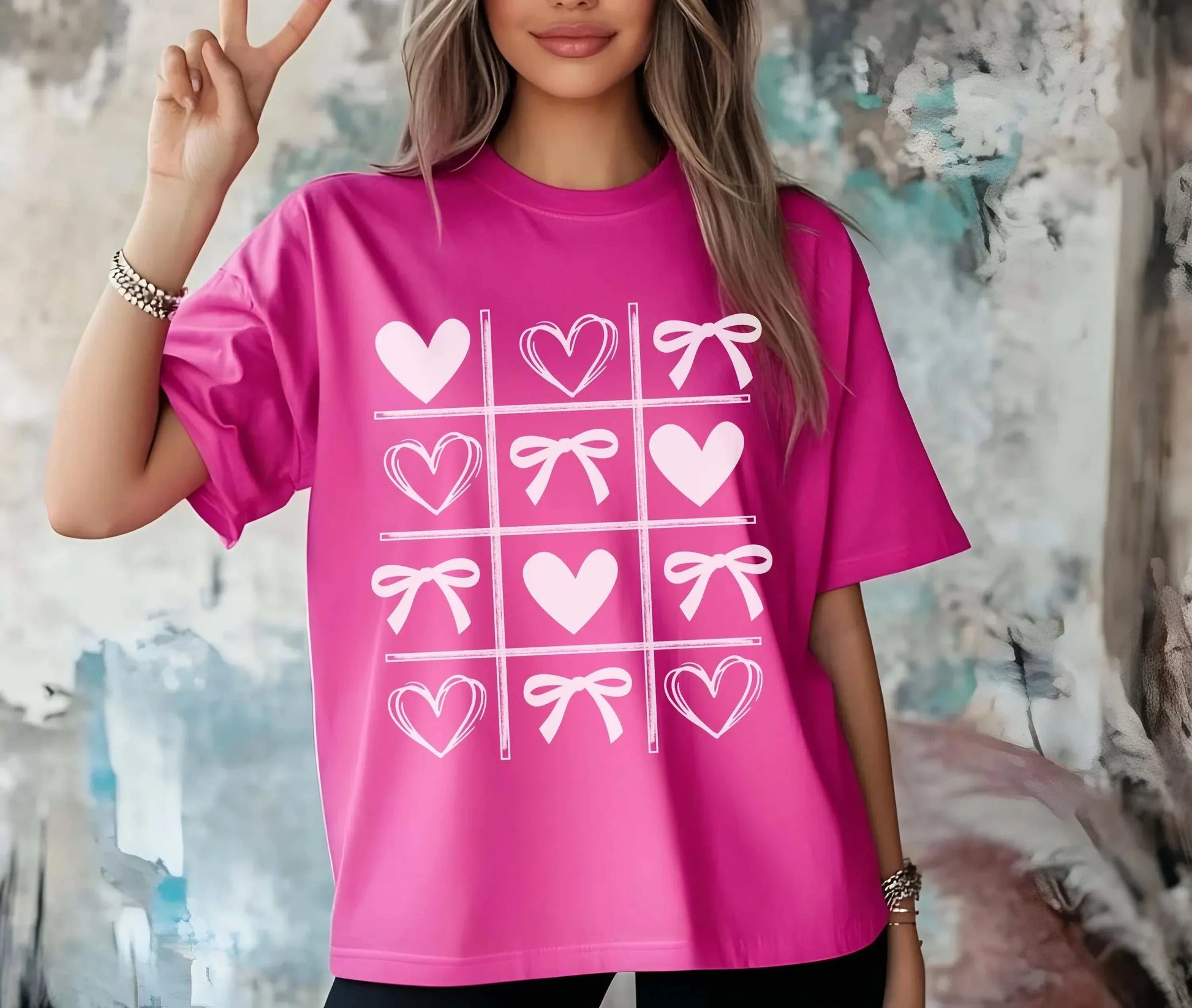 Valentine's Day shirt with hearts and bows in tic-tac-toe design on a pink tee.