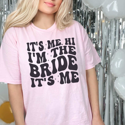 Custom bachelorette party bride shirt in pink with bold black "It’s Me, Hi I’m the Bride" text; ideal for celebrations.