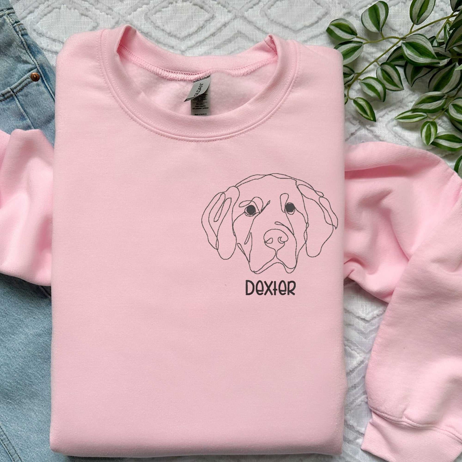 Pink classic crewneck sweatshirt with embroidered golden retriever face and name "Dexter" in block font, personalized dog lover gift.
