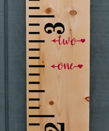 Height marker decals on wooden growth chart ruler.