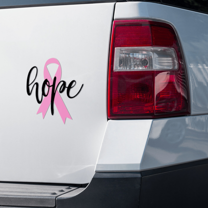 Pink ribbon "Hope" vinyl sticker on car back, symbol of support and resilience.