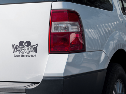 Car decal reading "Watchout for the Idiot Behind Me" on a vehicle's rear.