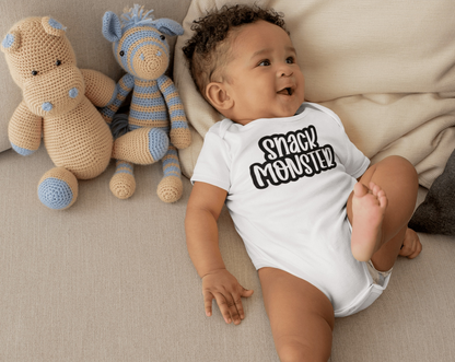 Unisex baby bodysuit "Snack Monster" in white cotton with baby and plush toys on a couch.