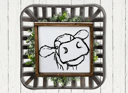 Rustic farmhouse cow wood sign with a black cow face on white background, framed with stained pine wood. Ideal for cottage-style décor.