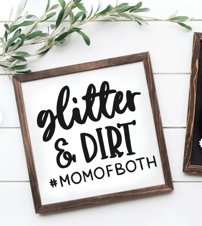 Handcrafted wood sign with "Glitter and Dirt #MomofBoth" in black lettering on a white background, framed in wood.