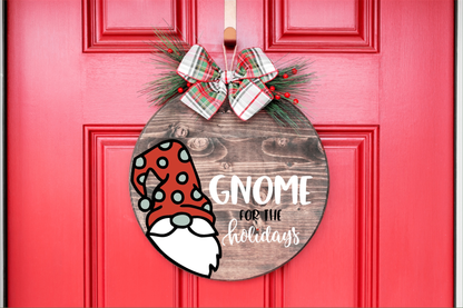 Holiday-themed gnome wood sign hanging on red door with ribbon.
