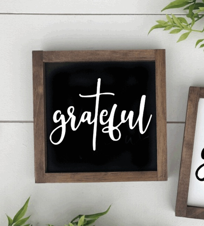 Handmade wood sign with "grateful" in white script on black background, rustic frame.