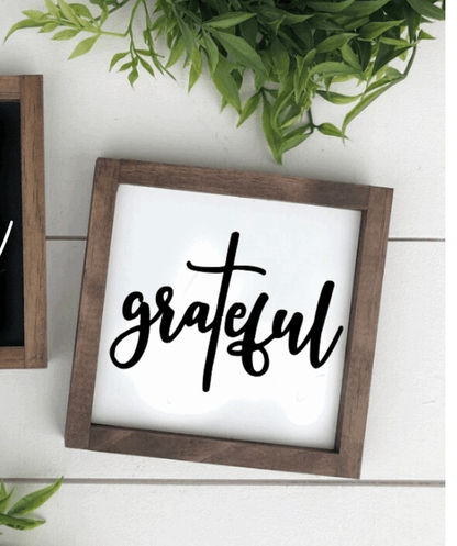 Handmade grateful wood sign with black lettering and stained frame.