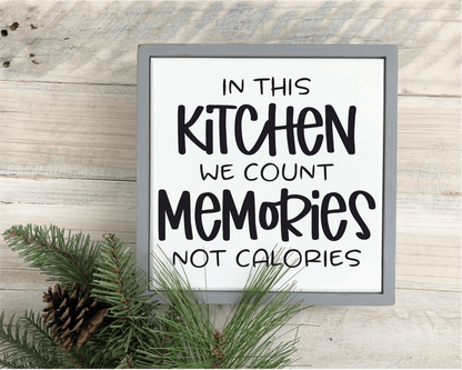 Framed wood sign with "In This Kitchen We Count Memories not Calories" text on white background with black lettering.
