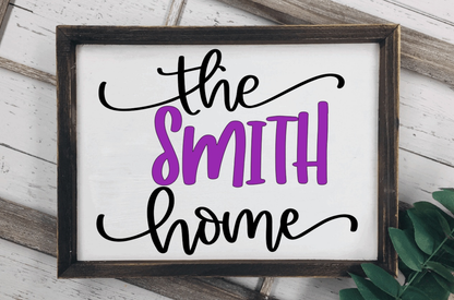 Framed wood family name sign with personalized purple and black lettering on a white background.
