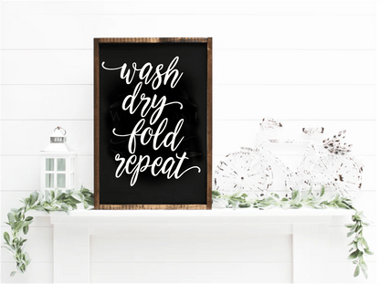 Handcrafted Wash Dry Fold Repeat wood sign with white script on black, framed in natural wood, ideal for laundry room decor.