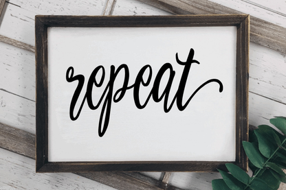 Rustic wood laundry room sign with "repeat" text and stained frame.